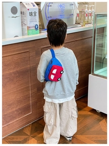 Close-up of kids cartoon car chest bag with red vehicle design and adjustable blue strap