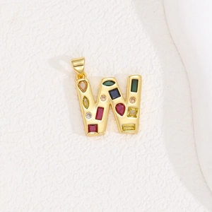 Macro shot of gold letter W pendant featuring colorful cubic zirconia stones and zircon inlay
