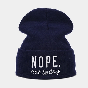 Détail du bonnet bleu marine avec broderie blanche NOPE not today sur le bord plié