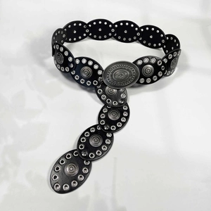 Détail de la ceinture corset noire avec rivets argentés et boucle vintage sculptée