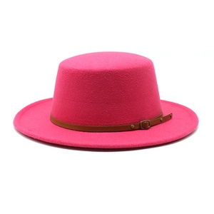 Gros plan détaillé d'un chapeau en feutre de laine rose fuchsia avec ceinture en cuir marron