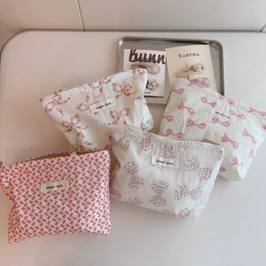 Flat lay of multiple floral print cotton makeup bags featuring ribbons and simple wish labels