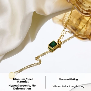 Macro detail of emerald-cut green zircon pendant on vacuum-plated gold titanium steel chain