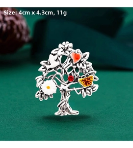 Detail view of a 4cm x 4.3cm silver Tree of Life brooch with colorful heart and flower motifs