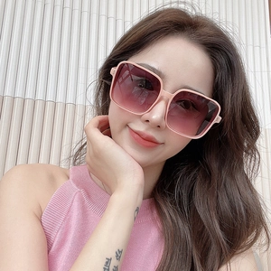 Close-up of stylish pink square oversized sunglasses with gradient lenses on a model
