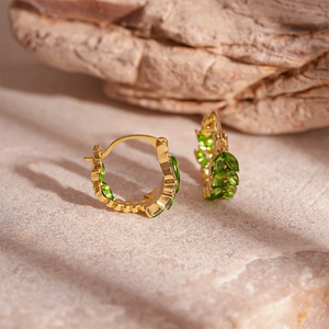 Elegant gold U-shaped ear cuffs with green leaf-shaped crystals and polished finish