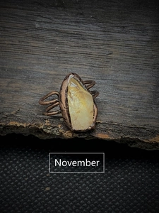 Macro view of raw November birthstone citrine in handcrafted vintage copper setting
