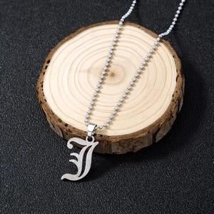 Detailed view of a silver ball chain necklace featuring a bold artistic letter J pendant