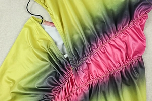 Detail of ruched vibrant tie-dye fabric with colorful gradient and pleated texture