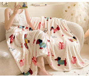Detail of plush cream flannel blanket with festive dog print on a cozy sofa