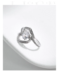Macro detail of S925 silver heart ring featuring sparkling zircon and intertwined band