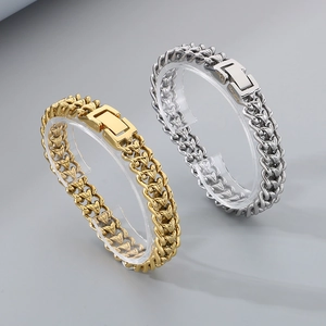Dettaglio di bracciali a catena intrecciata oro e argento con fibbie rettangolari