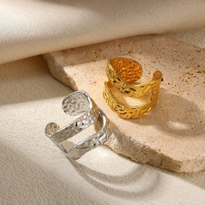 Golden and silver stainless steel rings with hammer texture on beige stone