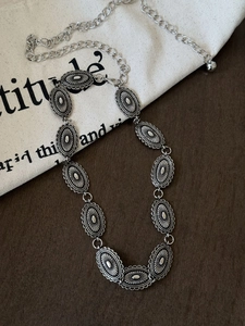 Detail of silver bohemian waist chain with turquoise butterfly and radial metal pieces