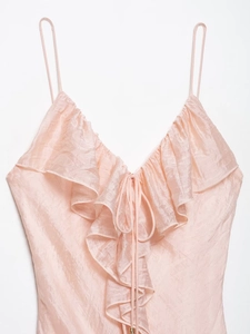 Detail of pink satin camisole featuring delicate ruffles and front tie-up V-neck design