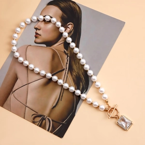 Detail of pearl necklace featuring golden OT clasp and rectangular crystal pendant detail