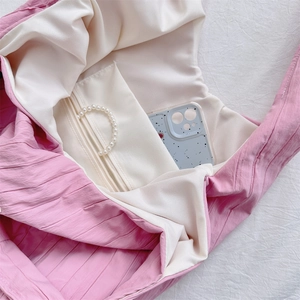 Detailed top view of pink pleated fabric tote bag interior with zipper pocket and lining