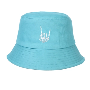 Detail of blue cotton bucket hat featuring white skull hand embroidery and stitching