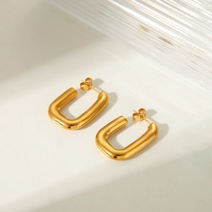 Minimalist gold U-shaped geometric hoop earrings in polished titanium steel on white background