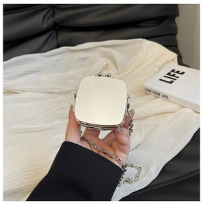 Close-up of a silver mirror-finish mini heart bag with stylish metal chain strap