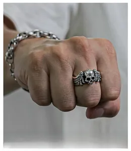 Detail of vintage punk skull ring with wings in antique silver finish on hand