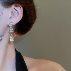 Detail of silver drop earrings with marquise cubic zirconia on female model