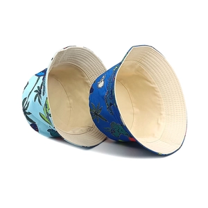Kids reversible bucket hats with cartoon dinosaur prints in light and dark blue colors