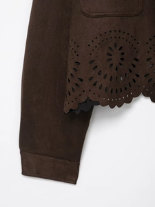 Détail de la veste en daim marron foncé avec motifs ajourés découpés au laser au bas