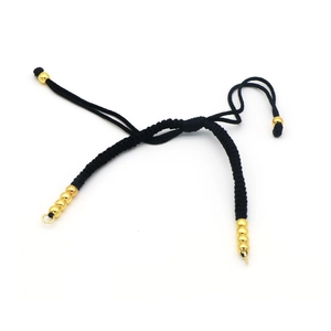 Detail of black woven rope bracelet with gold beads and metal loop for DIY jewelry