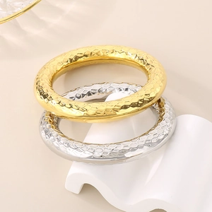 Detailed view of 18k gold and silver hammered texture stackable stainless steel bangles