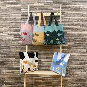 Knitted tote bags with ocean patterns like octopus and fish in various vibrant colors