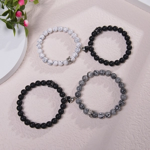 Detail of magnetic heart clasp on natural stone couple bracelets with crown charms