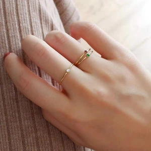 Detailed view of three minimalist 18K gold plated thin rings with colorful birthstones