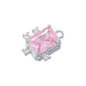 Macro shot of silver metal pendant with pink rectangular stone and white crystals