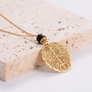Vintage style stainless steel necklace featuring a gold hollow leaf pendant on stone