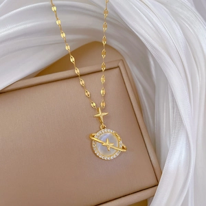Detail view of a gold planet necklace with white mother-of-pearl and zirconia on silk