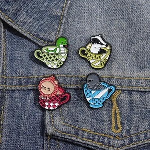 Cartoon animal pins in tea cups on denim jacket featuring eagle lion snake and badger