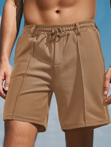 Detail of khaki men's mesh shorts featuring breathable fabric and elastic drawstring waist