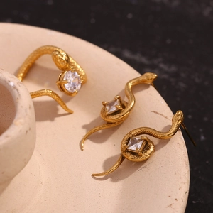 Détail de la bague et des boucles d'oreilles serpent dorées 18K avec zircons cubiques