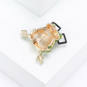 Back view of gold plated frog brooch with safety pin and green enamel details