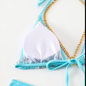 Detailed close-up of light blue bikini top with golden chain straps and removable pads