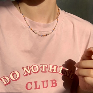 Colorful crystal beaded necklace on gold chain worn by a model in soft sunlight