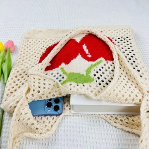Detail view of cream knit tote bag with cherry pattern showing daily storage capacity