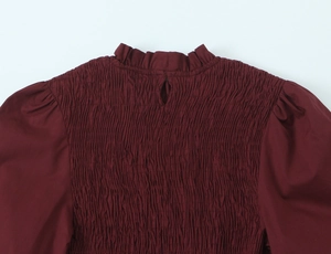 Détail du chemisier bordeaux smocké avec col montant à volants et ouverture goutte au dos