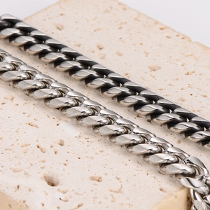 Polished silver and vintage black stainless steel curb chain bracelets on stone
