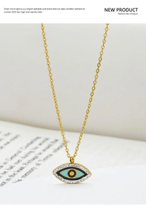 Macro detail of gold evil eye pendant with blue enamel and white rhinestones on titanium steel