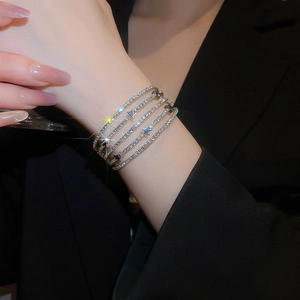 Detail of multi-layer silver wrap bracelet with sparkling stars and rhinestones on model