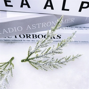 Detail of snowy PE pine needles with white flocking on a minimalist textured background
