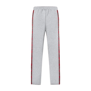 Detail of grey joggers featuring side red and green plaid stripes and soft knit fabric texture