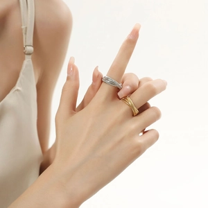 Close-up of gold and silver titanium steel rings with a braided wheat texture design